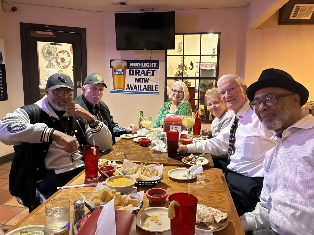 Six adults dining together at restaurant table