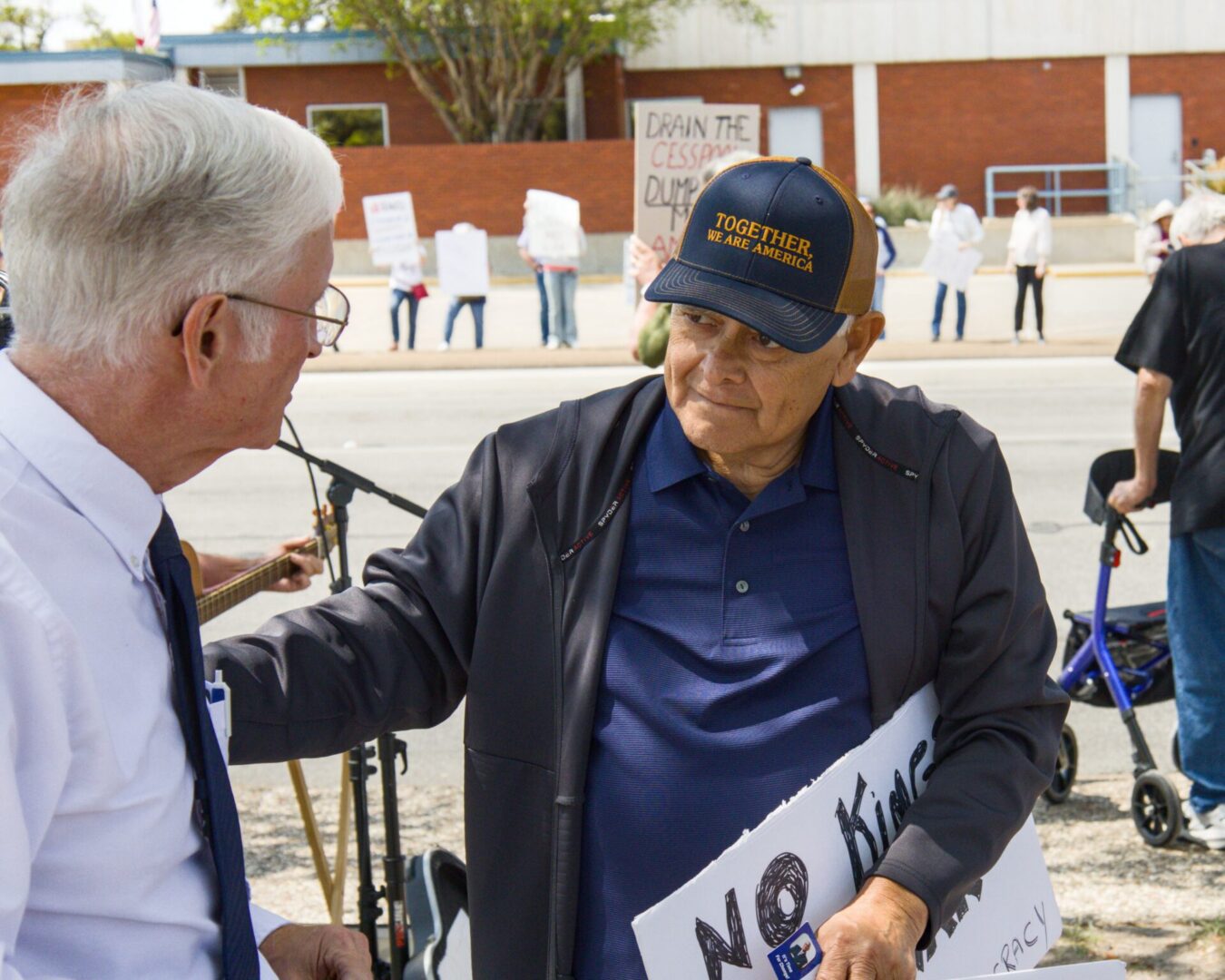 Two men conversing at outdoor protest