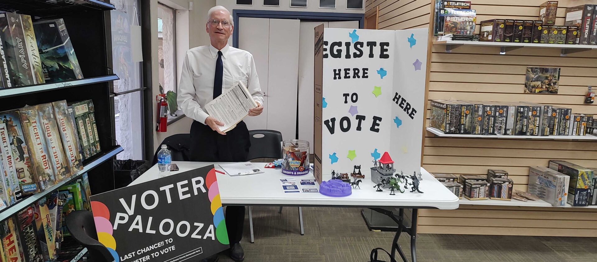 Person at voter registration table inside game store